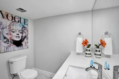 a white bathroom with a toilet and a sink at Euphoria - Miami Skyline & Water Views in Miami