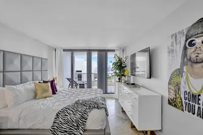 a bedroom with a bed and a dresser and a television at Euphoria - Miami Skyline & Water Views in Miami