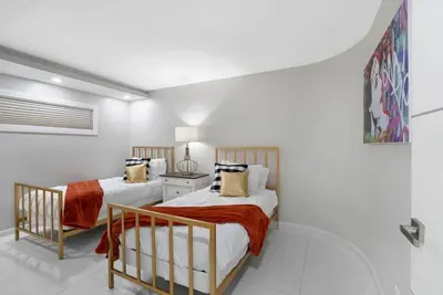 two beds in a room with white walls at Funkin' Fabulous! Water & City Views! 4BR in Miami