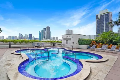 a swimming pool on the roof of a building with a city at Funkin' Fabulous! Water & City Views! 4BR in Miami