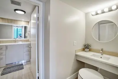 a bathroom with a toilet and a sink and a mirror at Stay in Love! Miami Skyline Views, Renovated in Miami