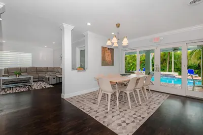 a dining room and living room with a table and chairs at Miami Dream Home/ Pool/Jacuzzi/ Fire Pit in Miami