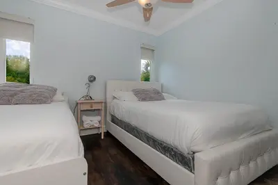 a white bedroom with two beds and a fan at Miami Dream Home/ Pool/Jacuzzi/ Fire Pit in Miami