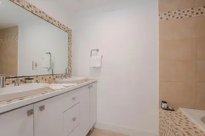 a bathroom with two sinks and a large mirror at Miami Dream Home/ Pool/Jacuzzi/ Fire Pit in Miami