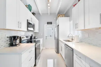 a white kitchen with white cabinets and a refrigerator at Together but with Privacy 3 Units and Private Pool in Fort Lauderdale