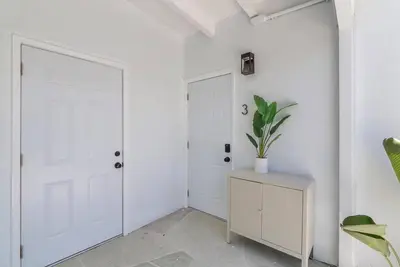a white hallway with a door and a potted plant at Together but with Privacy 3 Units and Private Pool in Fort Lauderdale