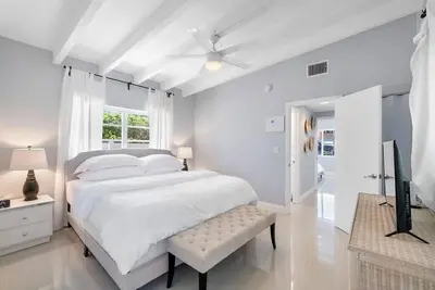 a white bedroom with a bed and a ceiling fan at Together but with Privacy 3 Units and Private Pool in Fort Lauderdale
