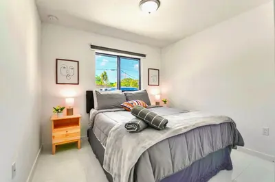 a bedroom with a large bed and a window at Stunning 3-Bedroom Duplex with Free Parking in Miami