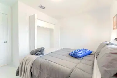 a bedroom with a bed with blue pillows on it at Stunning 3-Bedroom Duplex with Free Parking in Miami