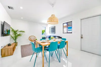 a dining room with a wooden table and blue chairs at Stunning 3-Bedroom Duplex with Free Parking in Miami