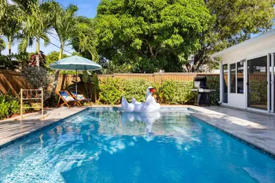 two white swans in a swimming pool at Casa Limon - Private Heated Pool Prime Location & Parking in Fort Lauderdale