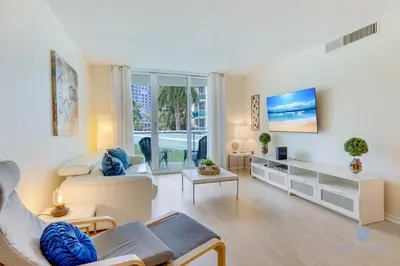 a living room with white furniture and a large window at Paradise Retreat, Near Beach, Casino, and More in Hollywood