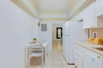 a kitchen with a table and a white refrigerator at Paradise Retreat, Near Beach, Casino, and More in Hollywood