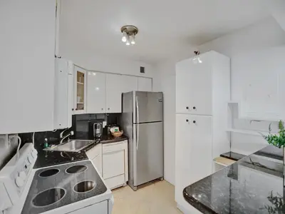 a kitchen with white cabinets and a stainless steel refrigerator at Modern Ocean View Condo Beach Service Unit 1206 in Miami Beach