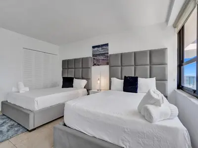 a bedroom with two beds and a large window at Cozy 2 Bedroom Ocean View Beach Service 707 in Miami Beach