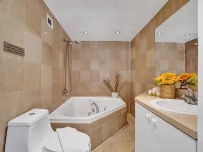 a bathroom with a tub and a toilet and a sink at Fantastic condo w beach service 615 in Miami Beach
