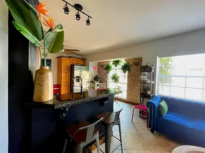 a living room with a counter and a blue couch at Fun Getaway: Hot Tub, Tiki Bar, Arcade Room in Hollywood