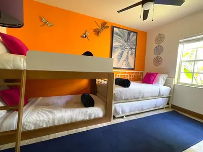 two bunk beds in a room with orange walls at Fun Getaway: Hot Tub, Tiki Bar, Arcade Room in Hollywood