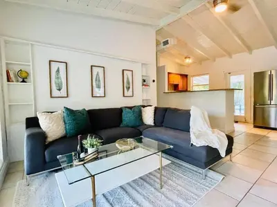 a living room with a blue couch and a glass table at Tropical Oasis House Private Pool Family Yard in Fort Lauderdale