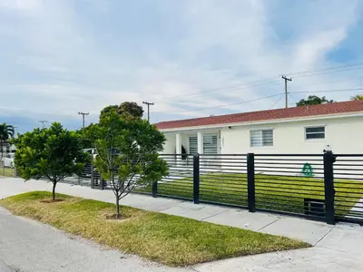 a house with a black fence and two trees at Nuvole Guest Suite in Miami