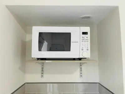 a microwave oven on a shelf in a kitchen at Nuvole Guest Suite in Miami