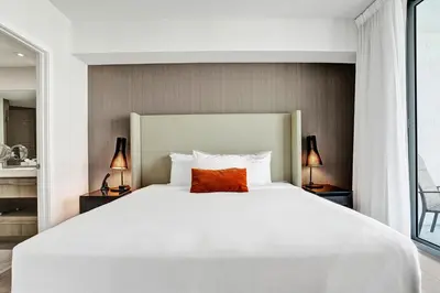 a bedroom with a large white bed with a red pillow at 2BR & 2BA Corner Suite Ocean Views at Hyde Beach House in Hollywood