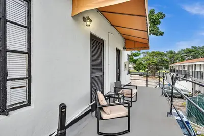a balcony with chairs and an umbrella on a building at New Year and Holiday Charming Miami Riverfront Stay! in Miami