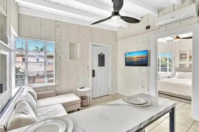 a white living room with a couch and a ceiling fan at New Year and Holiday Charming Miami Riverfront Stay! in Miami