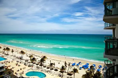 a view of the beach from the balcony of a resort at Marenas LATERAL ocean view daily refresh not included Fees collected at arrival in Sunny Isles Beach