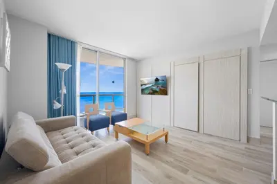 a living room with a couch and a table at Marenas LATERAL ocean view daily refresh not included Fees collected at arrival in Sunny Isles Beach