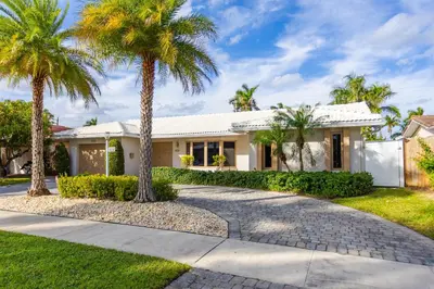 a house with palm trees in the driveway at Ultimate Luxury 5BR Villa near Hollywood Beach in Hollywood