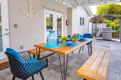 a wooden table with chairs and a blue bottle on it at Ultimate Luxury 5BR Villa near Hollywood Beach in Hollywood