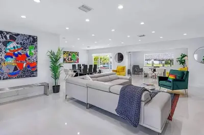 a white living room with a large couch and chairs at Ocean House in Dania Beach