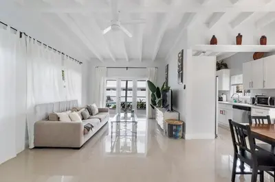 a white living room with a couch and a table at Seashell Walk To The Beach Comfy Beds Firepit Pool in Fort Lauderdale