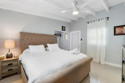 a bedroom with a large white bed with a headboard at Seashell Walk To The Beach Comfy Beds Firepit Pool in Fort Lauderdale