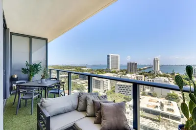 a living room with a couch and a table on a balcony at High-End Miami Condo with City and Bay Views!!! in Miami