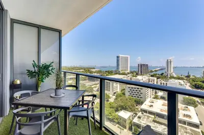 a balcony with a table and chairs and a view of the city at High-End Miami Condo with City and Bay Views!!! in Miami