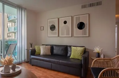 a living room with a black couch and a table at Tides Condominiums in Hollywood
