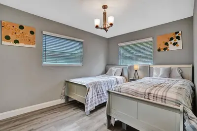 two beds in a bedroom with two windows at Luxury 3bd/2ba near Beach & Las Olas in Fort Lauderdale