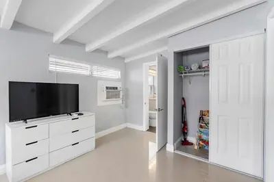 a living room with a flat screen tv on a white cabinet at Coconut Walk To The BeachComfy Beds Firepit Pool in Fort Lauderdale