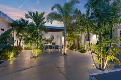 a courtyard with palm trees and a building at Coconut Walk To The BeachComfy Beds Firepit Pool in Fort Lauderdale