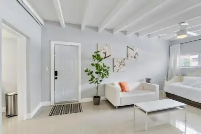 a white living room with a white couch and a table at Coconut Walk To The BeachComfy Beds Firepit Pool in Fort Lauderdale