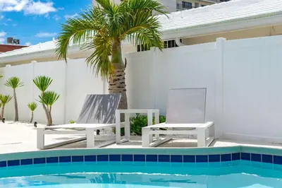 two chairs sitting next to a swimming pool at The Sandbar Walk To Beach Comfy Beds Firepit Pool in Fort Lauderdale
