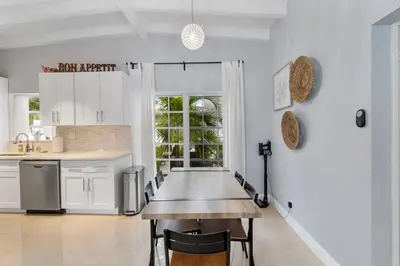 a kitchen with a table and chairs in it at The Sandbar Walk To Beach Comfy Beds Firepit Pool in Fort Lauderdale