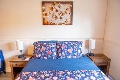 a bedroom with a bed with blue sheets and two lamps at 5 min to airport and 15 min to beach! in Fort Lauderdale