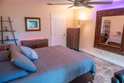 a bedroom with a bed and a mirror at 5 min to airport and 15 min to beach! in Fort Lauderdale