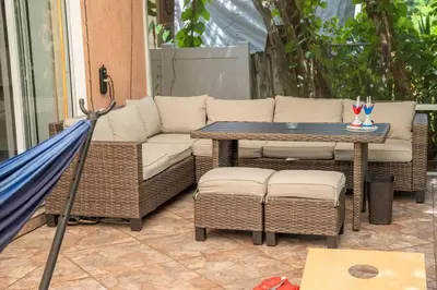 a patio with a couch and a table and an umbrella at 5 min to airport and 15 min to beach! in Fort Lauderdale