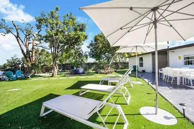 a patio with two chairs and an umbrella at Dior Lake Front Villa With Infinity Pool in Miami Gardens