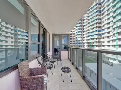 an apartment balcony with chairs and tables and windows at Oceanfront Haven Retreat Beach Service 502 in Miami Beach
