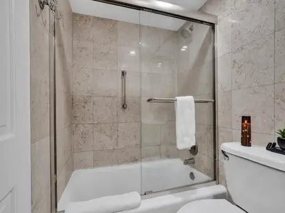 a bathroom with a shower with a tub and a toilet at Oceanfront Haven Retreat Beach Service 502 in Miami Beach
